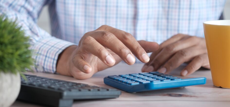 Man using calculator to determine mortgage repayments
